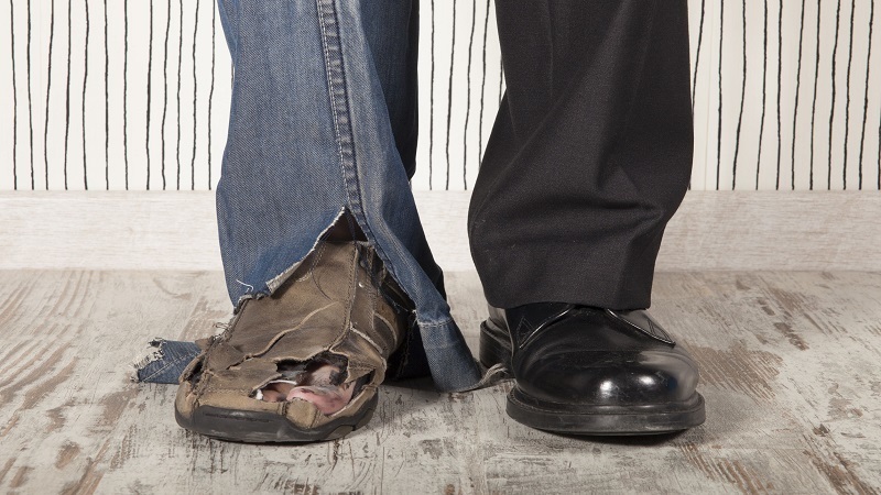 one loafer foot, one homeless foot, representing the concept of creating wealth creation