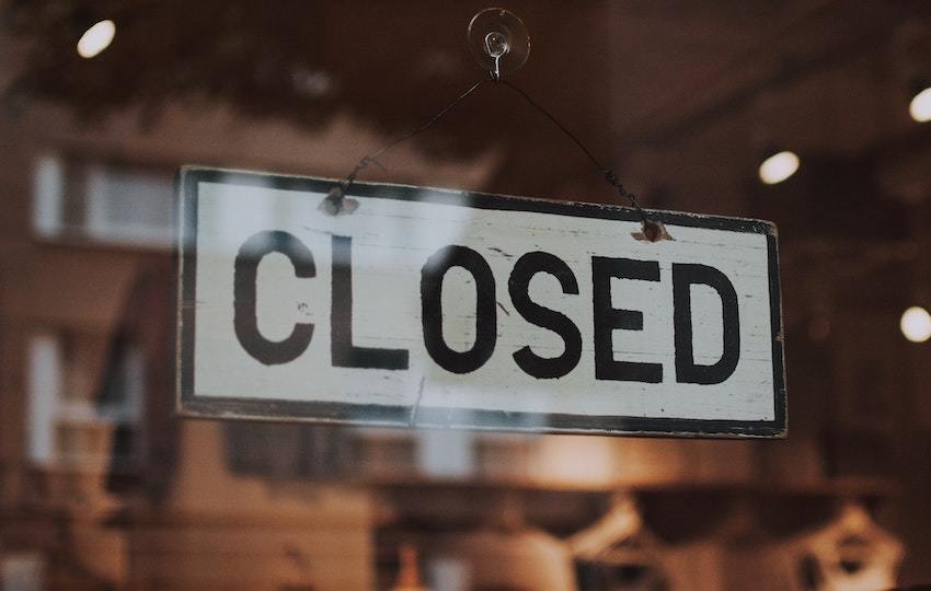 A business closed sign, symbolizing the sale of a business through a share sale or an asset sale
