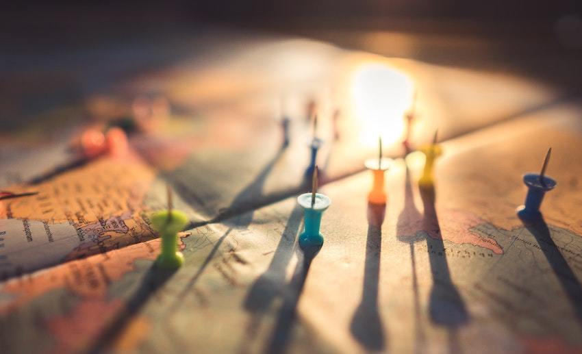 pushpins on a map, symbolizing investment strategy