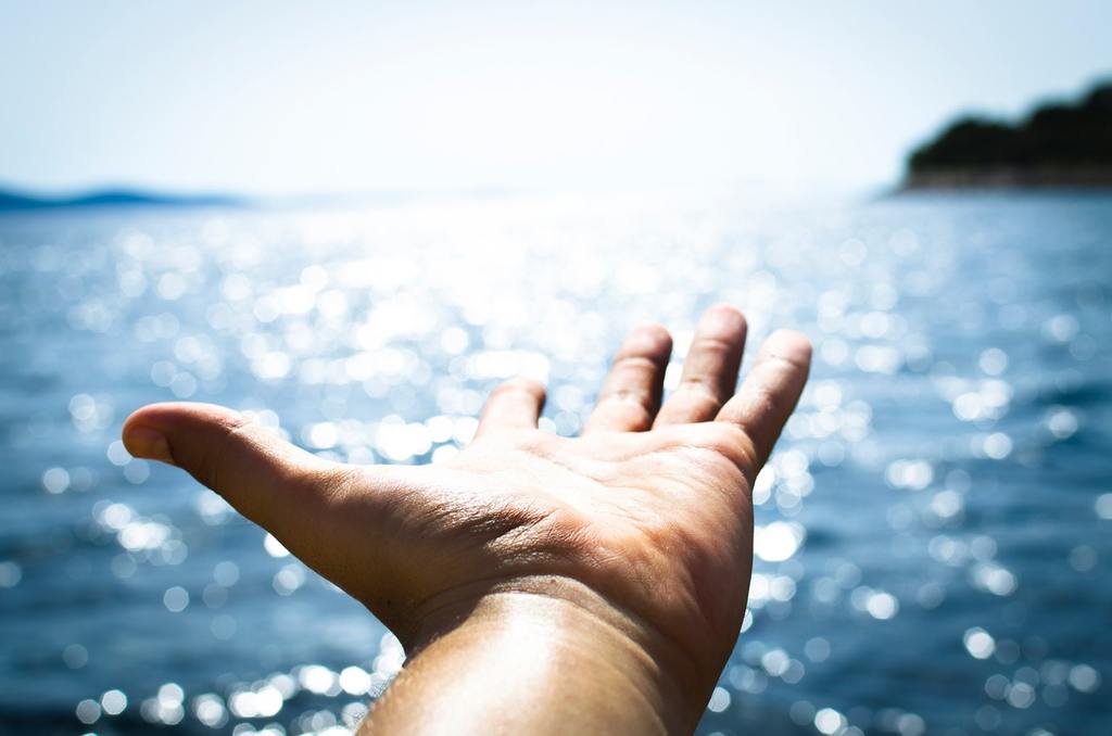 A hand reaches into the sea, as if optimistic about the future of a private equity investor