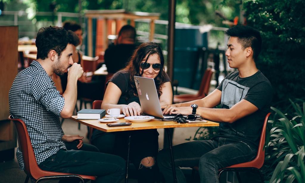 A group of Millennials programmers gather at a coffeeshop to discuss VC funding, or venture capital funding, for their startup