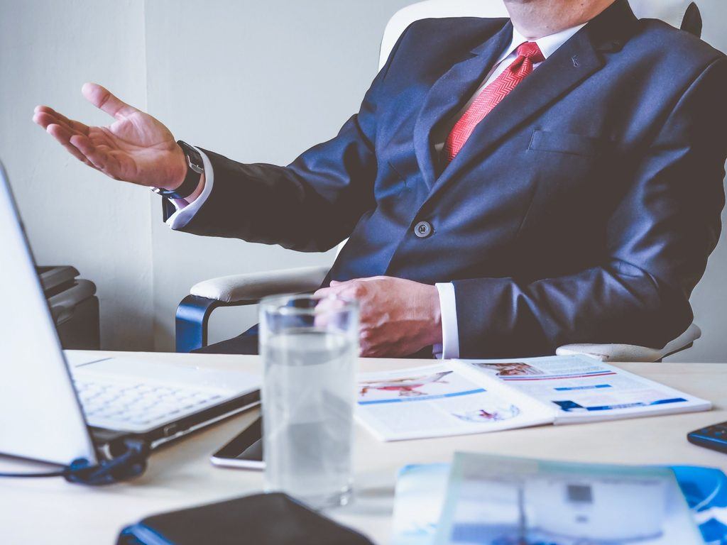 a blurred image of a boss in a blue business suit, representing hiring a lawyer in light of COVID 19