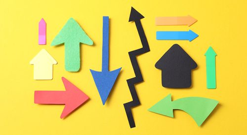 Different paper arrows on yellow background